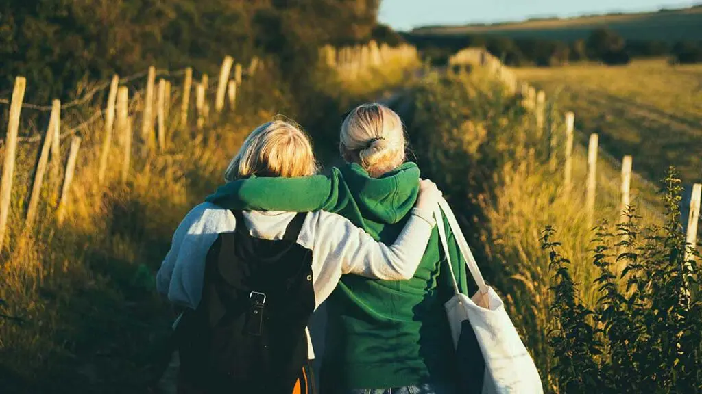 two women walking together in the countryside
